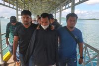 Pemilik rumah kontrakan yang dijadikan tempat penampungan PMI Ilegal di Karimun ditetapkan sebagai tersangka dan dibawa ke Mako Ditpolairud Polda Kepri | Foto: Bustomi