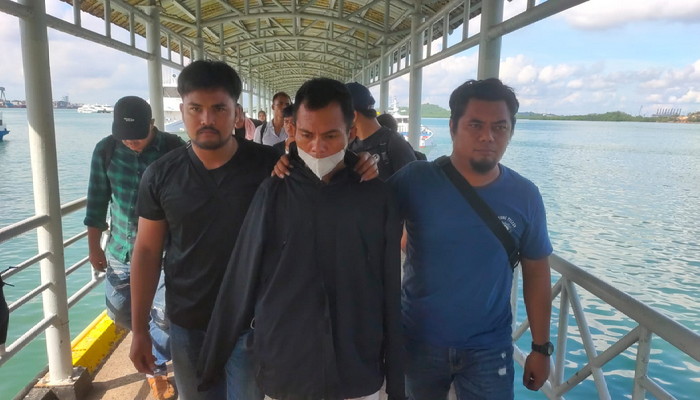 Pemilik rumah kontrakan yang dijadikan tempat penampungan PMI Ilegal di Karimun ditetapkan sebagai tersangka dan dibawa ke Mako Ditpolairud Polda Kepri | Foto: Bustomi