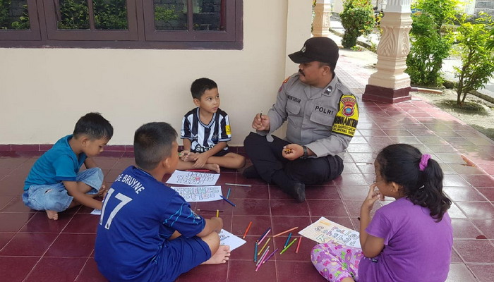 Bhabinkamtibmas Polsek Meral, Aipda Samson R Tarigan mengajak Anak-anak bermain dan menggambar | Foto: Bustomi