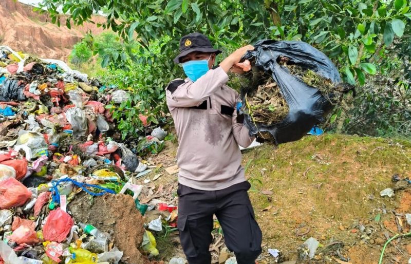 Kapolsek Tebing, AKP Binsar Samosir turun langsung ke TPS membersihkan sampah yang menumpuk | Foto: Nichita