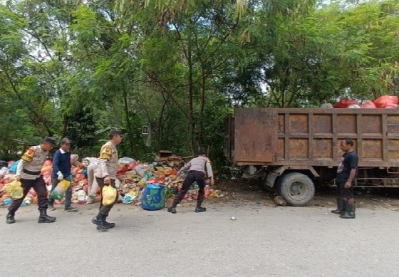 Personel Polsek Tebing bersama masyarakat membersihkan sampah menumpuk di TPS Kampung Harapan | Foto: Nichita