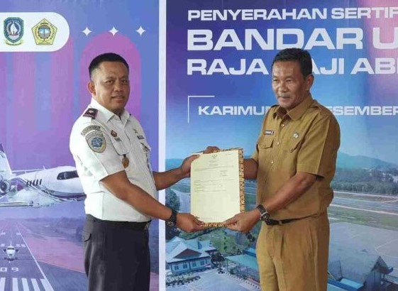Kepala Bandara RHA Karimun, Fanani Zuhri menerima sertifikat lahan seluas 58 hektare yang diserahkan oleh Sekretaris Daerah Kabupaten Karimun, Djunaidi | Foto: Andri
