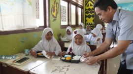 Pegawai PT Timah saat memberikan makanan bergizi gratis kepada pelajar sekolah dasar di Kabupaten Bangka Tengah | Foto: Zonamu/Humas PT. Timah