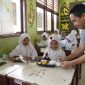 Pegawai PT Timah saat memberikan makanan bergizi gratis kepada pelajar sekolah dasar di Kabupaten Bangka Tengah | Foto: Zonamu/Humas PT. Timah