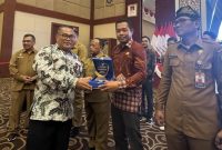 Kadis Kominfo Lingga saat menerima penghargaan (Foto : Zonamu/Diskominfo)