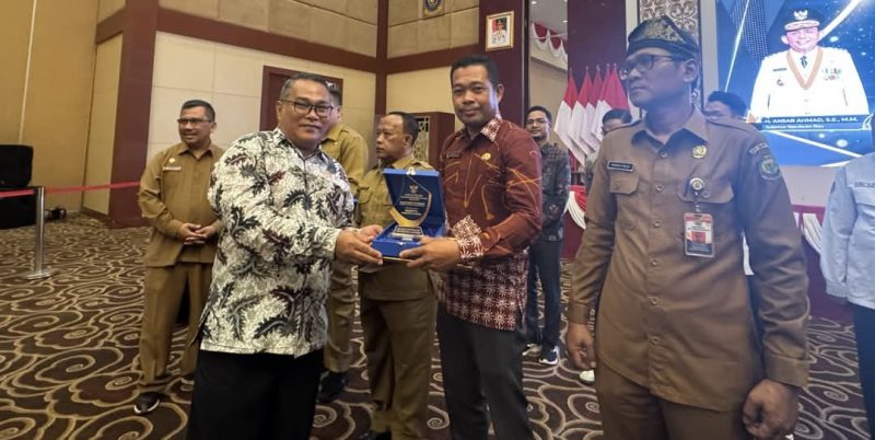 Kadis Kominfo Lingga saat menerima penghargaan (Foto : Zonamu/Diskominfo)
