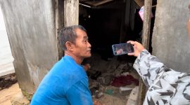 Seorang warga saat menunjukan korban tertimpa reruntuhan tembok pembantas (Foto : Zonamu/Wandi)