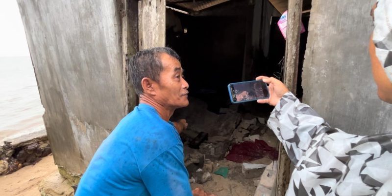 Seorang warga saat menunjukan korban tertimpa reruntuhan tembok pembantas (Foto : Zonamu/Wandi)