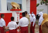 Guru SDN 010 Singkep saat memberikan penjelasan tentang tugu timah kepada para siswa (Foto : Zonamu/Wandi)