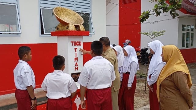 Guru SDN 010 Singkep saat memberikan penjelasan tentang tugu timah kepada para siswa (Foto : Zonamu/Wandi)