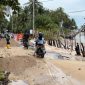 Potert ketika warga hendak melintas di jalan yang rusak akibat abrasi pantai (Foto : Zonamu/Wandi)