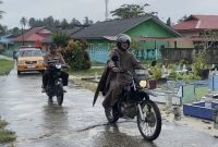 Bhabinkamtibas Kelurahan Dabo saat mengawal jenazah warga yang akan di makamkan (Foto : Zonamu/Hendri)