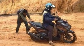 Salah seorang warga saat mendorong motor karena kondisi jalan yang licin (Foto : Zonamu/Paino)