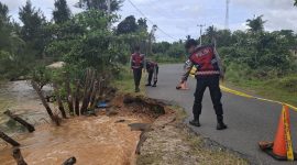 Personil Polres Lingga beberapa waktu lalu saat melakukan police line di jalan raya yang terkikis akibat abrasi pantai (Foto : Zonamu/Ist)