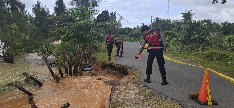 Personil Polres Lingga beberapa waktu lalu saat melakukan police line di jalan raya yang terkikis akibat abrasi pantai (Foto : Zonamu/Ist)