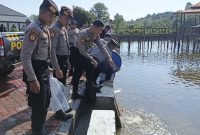 Personil Polres Lingga saat melakukan penebaran benih ikan nila (Foto : Zonamu/Wandi)