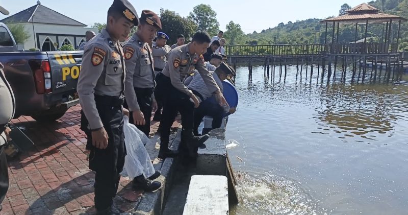 Personil Polres Lingga saat melakukan penebaran benih ikan nila (Foto : Zonamu/Wandi)