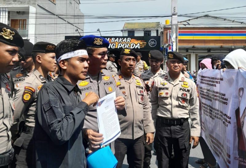 Mahasiswa saat menyampaikan tuntutannya di hadapan petugas Mapolda Riau | Foto: Zonamu/Ibnu