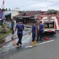 Petugas damkar saat membersihkan jalan akibat tumpahan minyak solar | Foto : Zonamu/Wandi