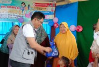Kadinkes Lingga dr. Bukit Tua Rayanto Gultom saat memberikan bingkisan kepada warga Desa Benan | Foto : Zonamu/Diskominfo Lingga