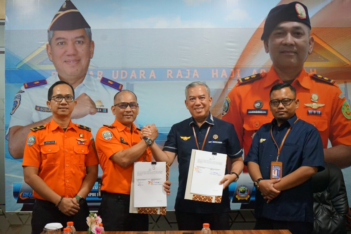 Kepala UPBU RHA, M. Subiat Wiranata Kusumah (tengah kanan), dan Kepala Basarnas Tanjungpinang, Fazzli (tengah kiri), menunjukkan dokumen Letter of Operational Coordination Agreement (LOCA) yang baru saja ditandatangani di Karimun, Selasa (23/12/2025) | Foto: Zonamu/Humas Bandara RHA