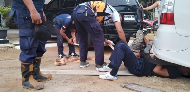 Petugas Damkar saat membantu warga saat mobilnya terbenam di pasir lunak | Foto : Zonamu/Humas Damkar