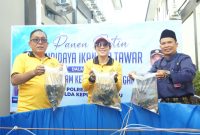 Kapolres Karimun AKBP Yunita Stevani bersama Plt. Kepala Dinas Perikanan Kabupaten Karimun, Sapridin menunjukkan hasil panen ikan lele di belakang Gedung Satya Haprabu Polres Karimun, Jumat (30/1/2026) | Foto: Zonamu/Humas Polres Karimun