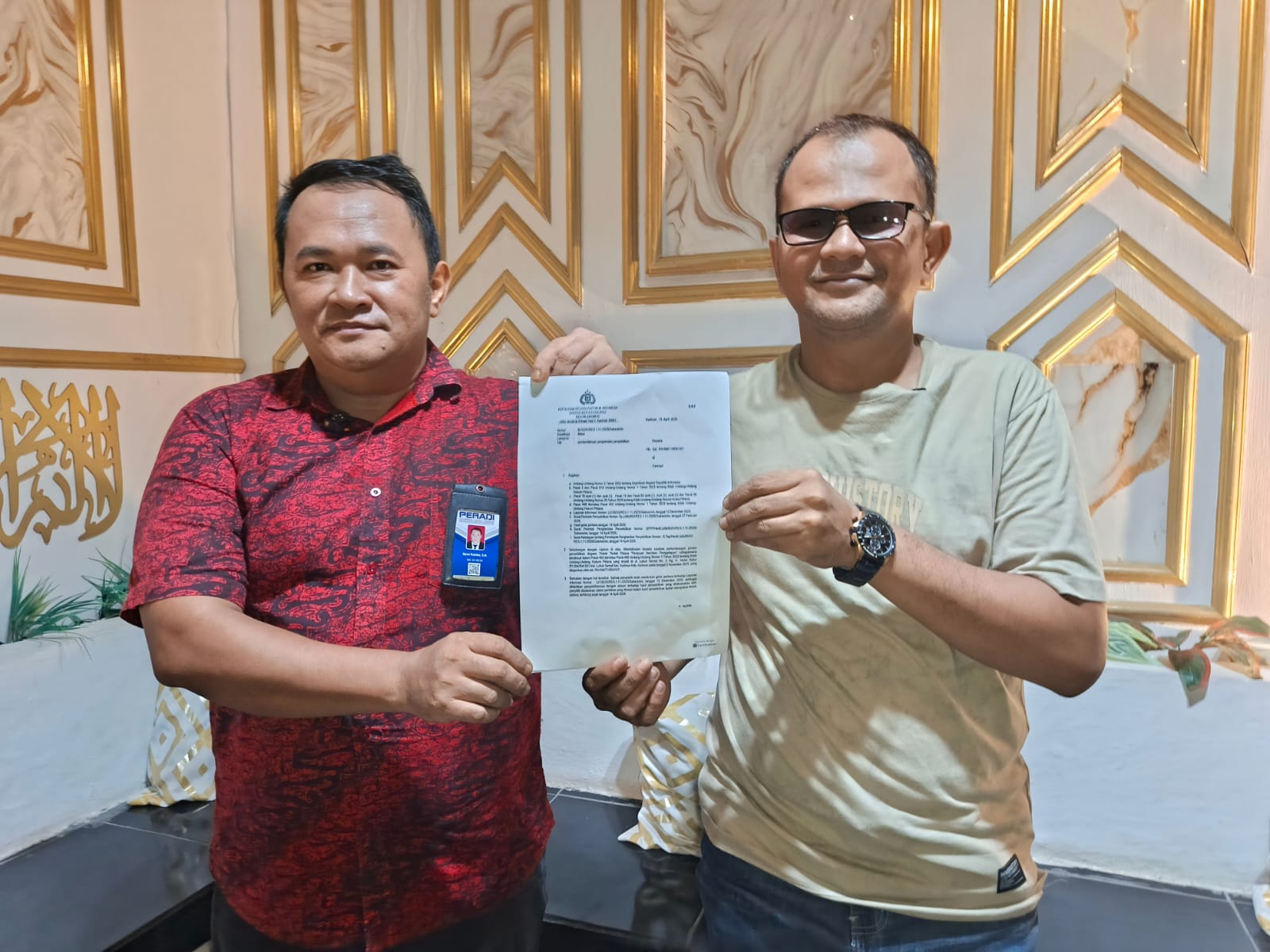 Tanjung Buser (kanan) didampingi kuasa hukumnya, Ilfan Rambe (kiri), menunjukkan surat SP2Lid saat menggelar konferensi pers di kediamannya, Karimun, Jumat (17/4/2026) | Foto: Bustomi