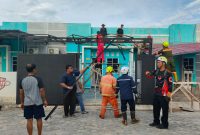 Sejumlah warga Perumahan Gladiola 1, Kelurahan Tebing, bersama personel BPBD Karimun gotong royong membongkar material kanopi rumah yang rusak berat akibat diterjang angin puting beliung, Selasa (14/4/2026) | Foto: Bustomi