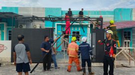 Sejumlah warga Perumahan Gladiola 1, Kelurahan Tebing, bersama personel BPBD Karimun gotong royong membongkar material kanopi rumah yang rusak berat akibat diterjang angin puting beliung, Selasa (14/4/2026) | Foto: Bustomi