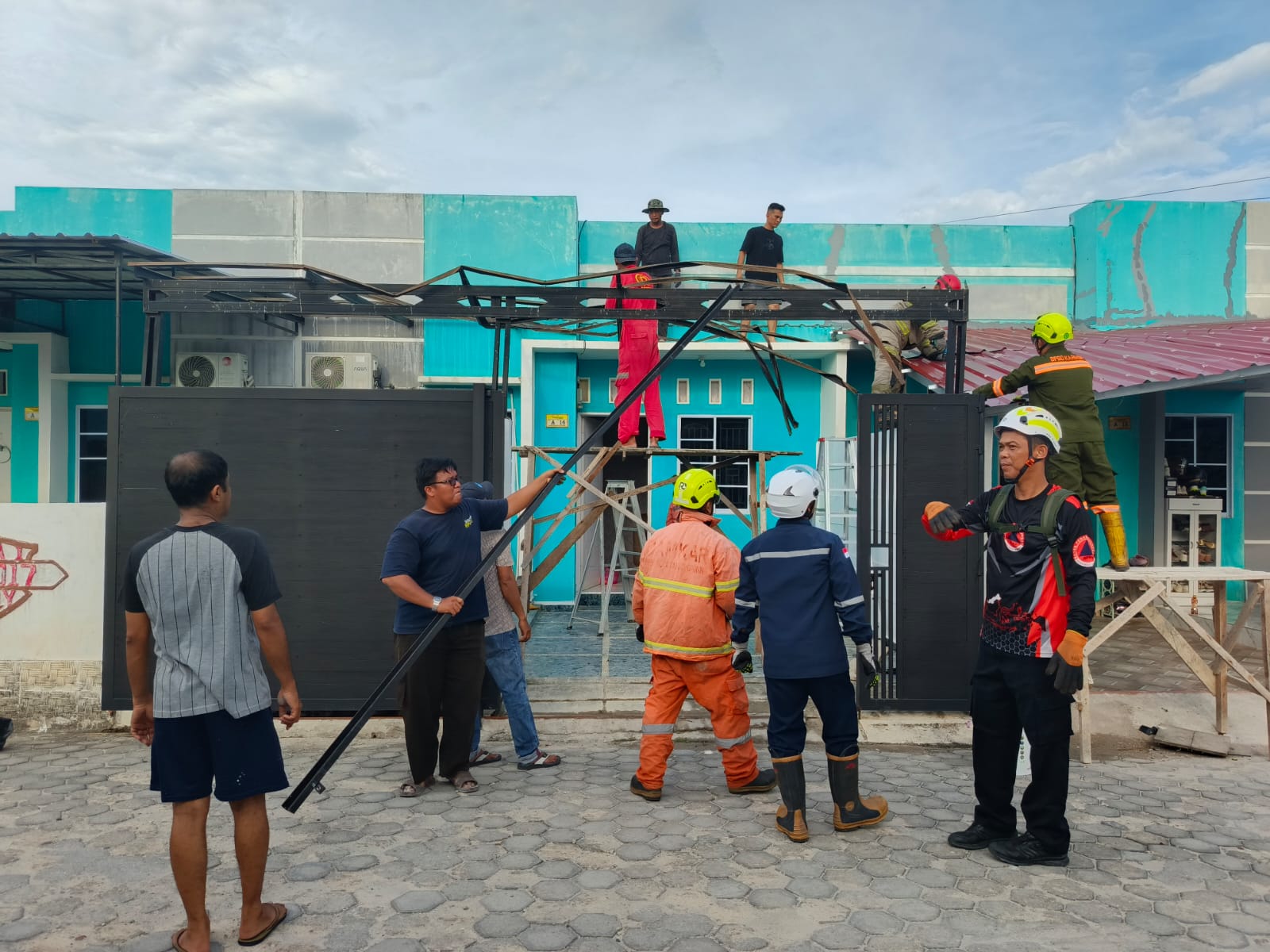 Sejumlah warga Perumahan Gladiola 1, Kelurahan Tebing, bersama personel BPBD Karimun gotong royong membongkar material kanopi rumah yang rusak berat akibat diterjang angin puting beliung, Selasa (14/4/2026) | Foto: Bustomi