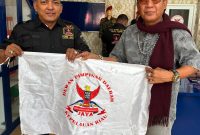 Dian Bangun Sari mengibarkan bendera GRIB jaya, usai menerima SK sebagai Ketua DPC GRIB Jaya Karimun | Foto: Zonamu/Bustomi