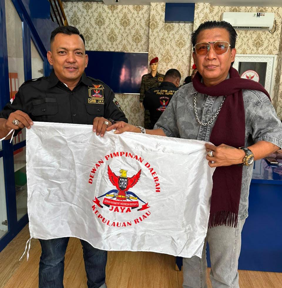 Dian Bangun Sari mengibarkan bendera GRIB jaya, usai menerima SK sebagai Ketua DPC GRIB Jaya Karimun | Foto: Zonamu/Bustomi